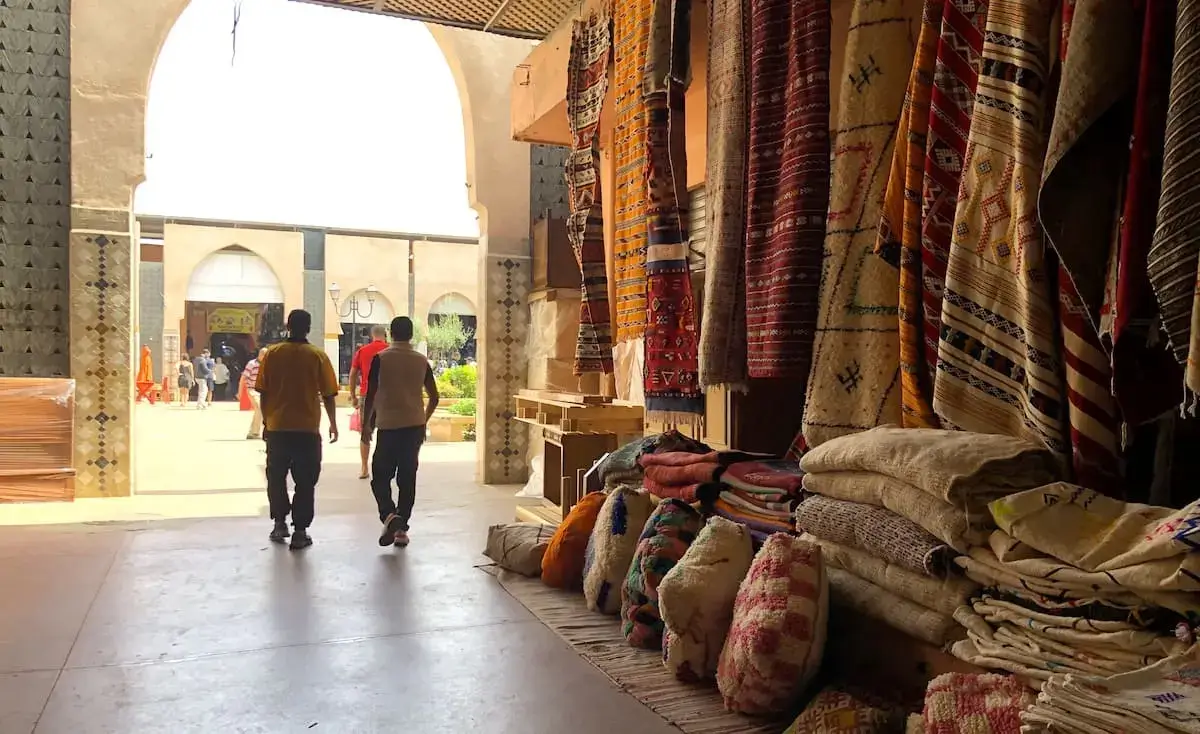 Tapis berbères faits main en laine exposés au Souk El Had Agadir, artisanat marocain authentique et motifs traditionnels amazighs